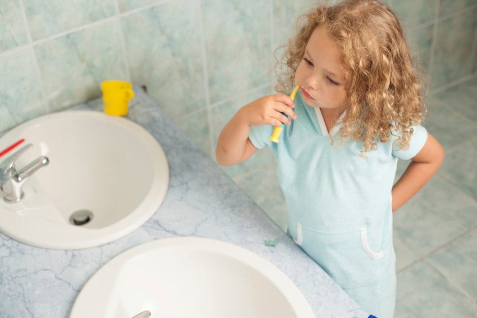 Child brushing teeth with parent